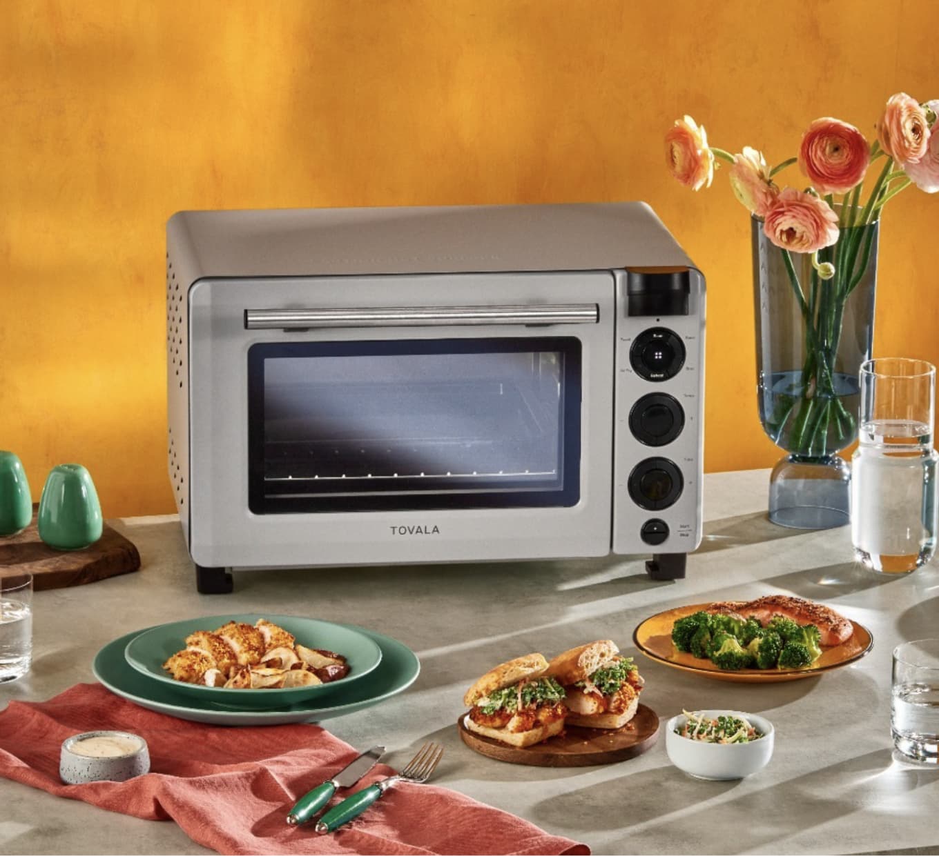 Tovala smart oven sitting on a table surrounded by food