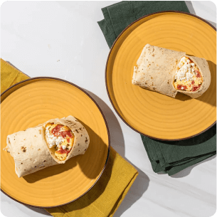Two breakfast burritos on yellow plates